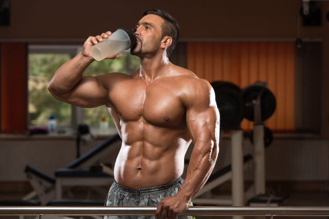 man in gym drinking water